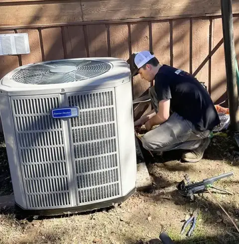 A Humphrey AC tech works on an outside unit in Hughes Springs