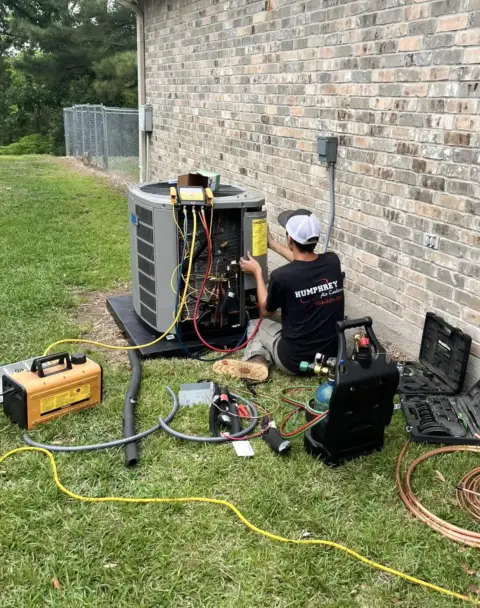 A Humphrey Air Conditioning technician performs a diagnostic check on an HVAC unit.