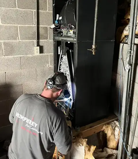 Technician works on an air handler to repair it back to working order.