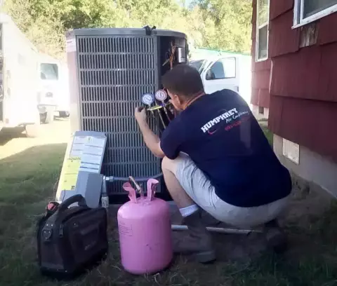 A Humphrey A/C tech tests the freon level of an air conditioner unit to ensure proper function.