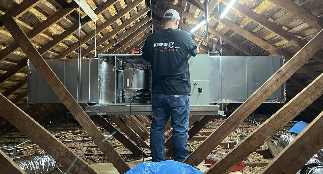 Tech works on an attic unit